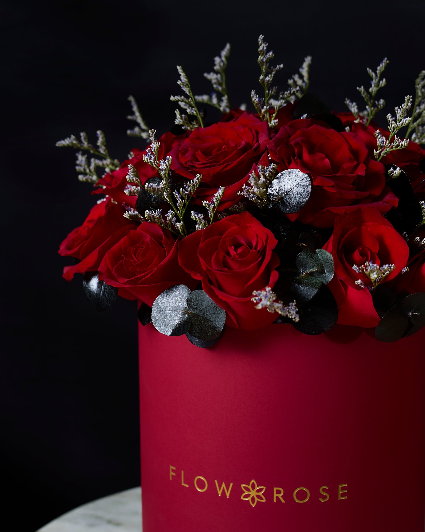 Red roses in a pink box with 'Flowrose' branding on a dark background