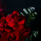 Bouquet of red roses with green leaves on a dark background